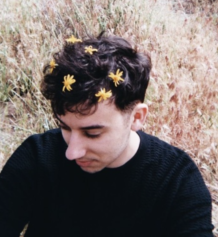 Portrait of Elias Abid with flowers in his hair.
