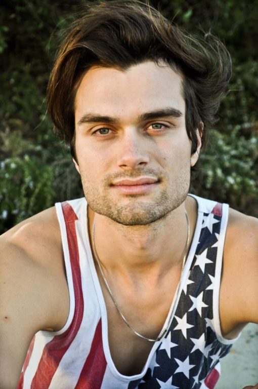 A portrait of Seth Reger wearing a tank top with an American flag print.